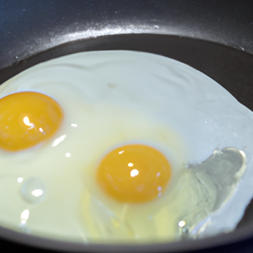 A close-up of a non-stick frying pan with eggs cooking